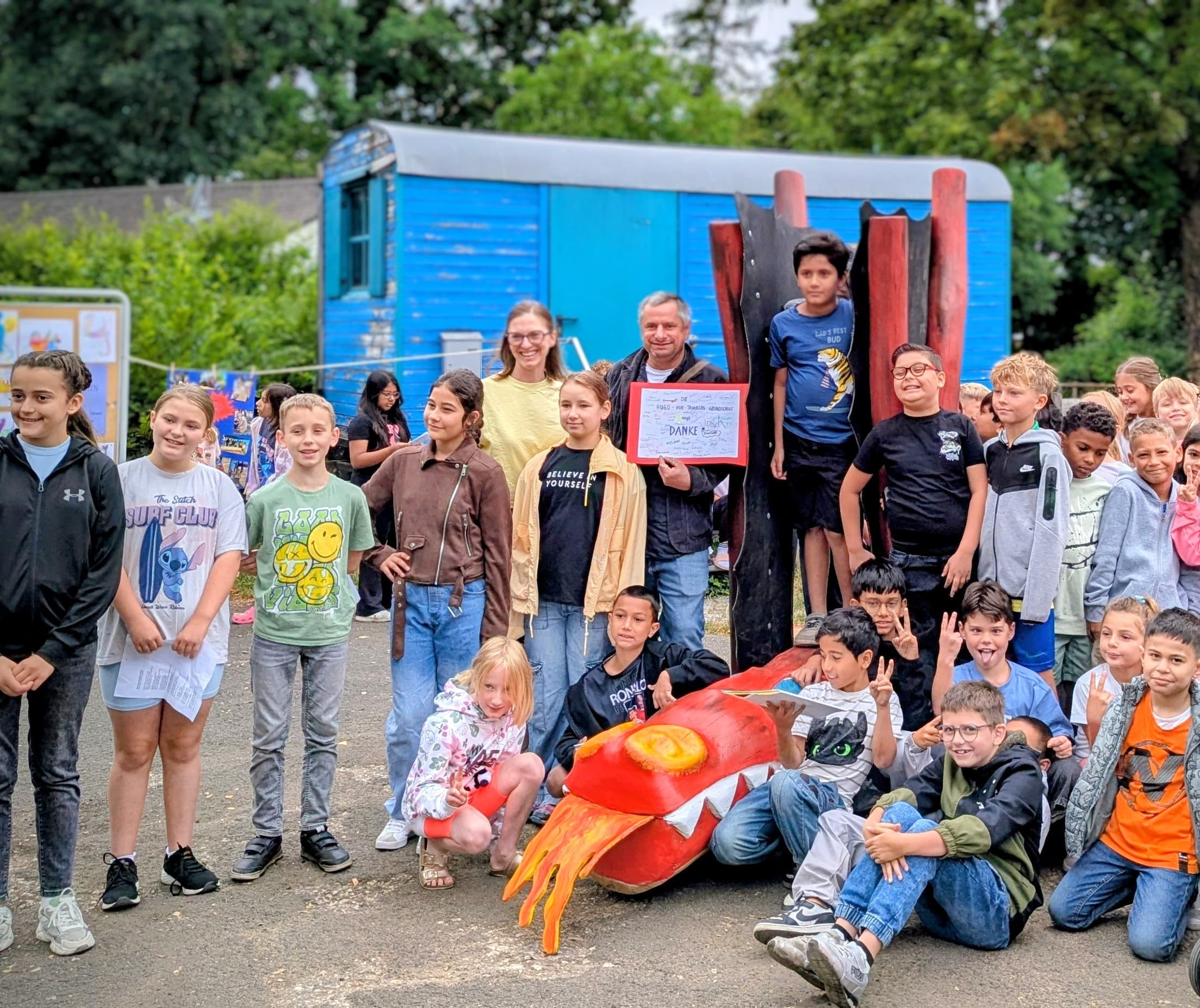 Holzskulptur eines Drachen („Hugo“) im Pausenhof der Hugo-von-Trimberg Grund- und Mittelschule.