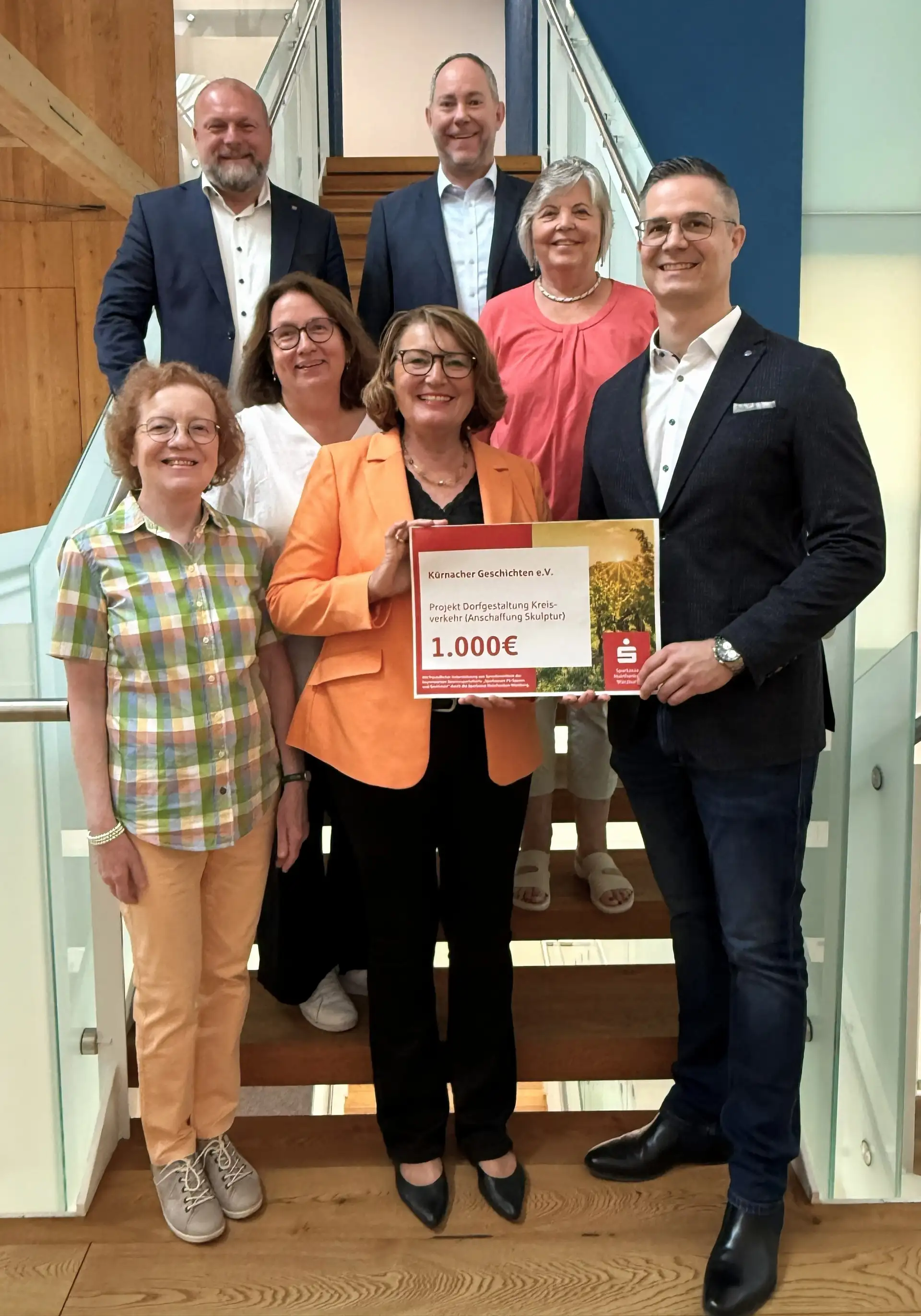 Scheckübergabe an den Verein Kürnacher Geschichte(n): Personen vorn und hinten im Bild, darunter Landrat Thomas Eberth und Heiko Därr.