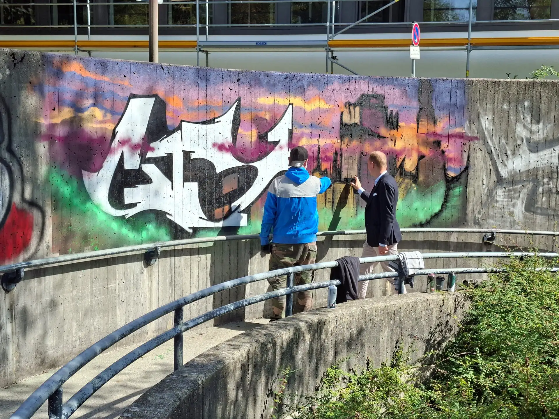 Graffiti an einer Betonwand in einer Unterführung.