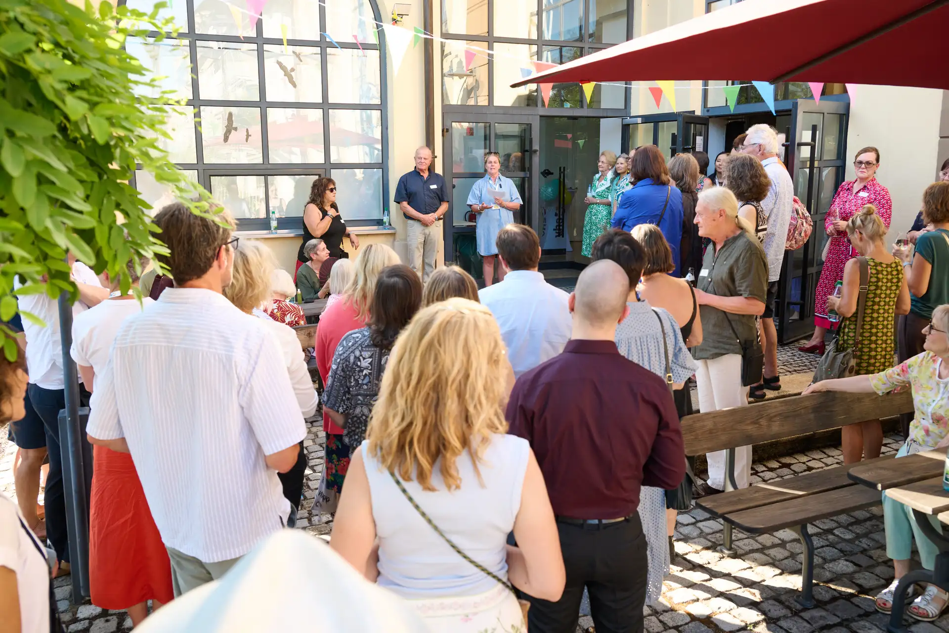 Die Volkshochschule als Ort der Begegnung: Dozentinnen und Dozenten beim Sommerfest zum 80-jährigen Bestehen auf der Terrasse des Alten E-Werks. Anlage 2: Plakat zur VHS-Semestereröffnung am 17. September.