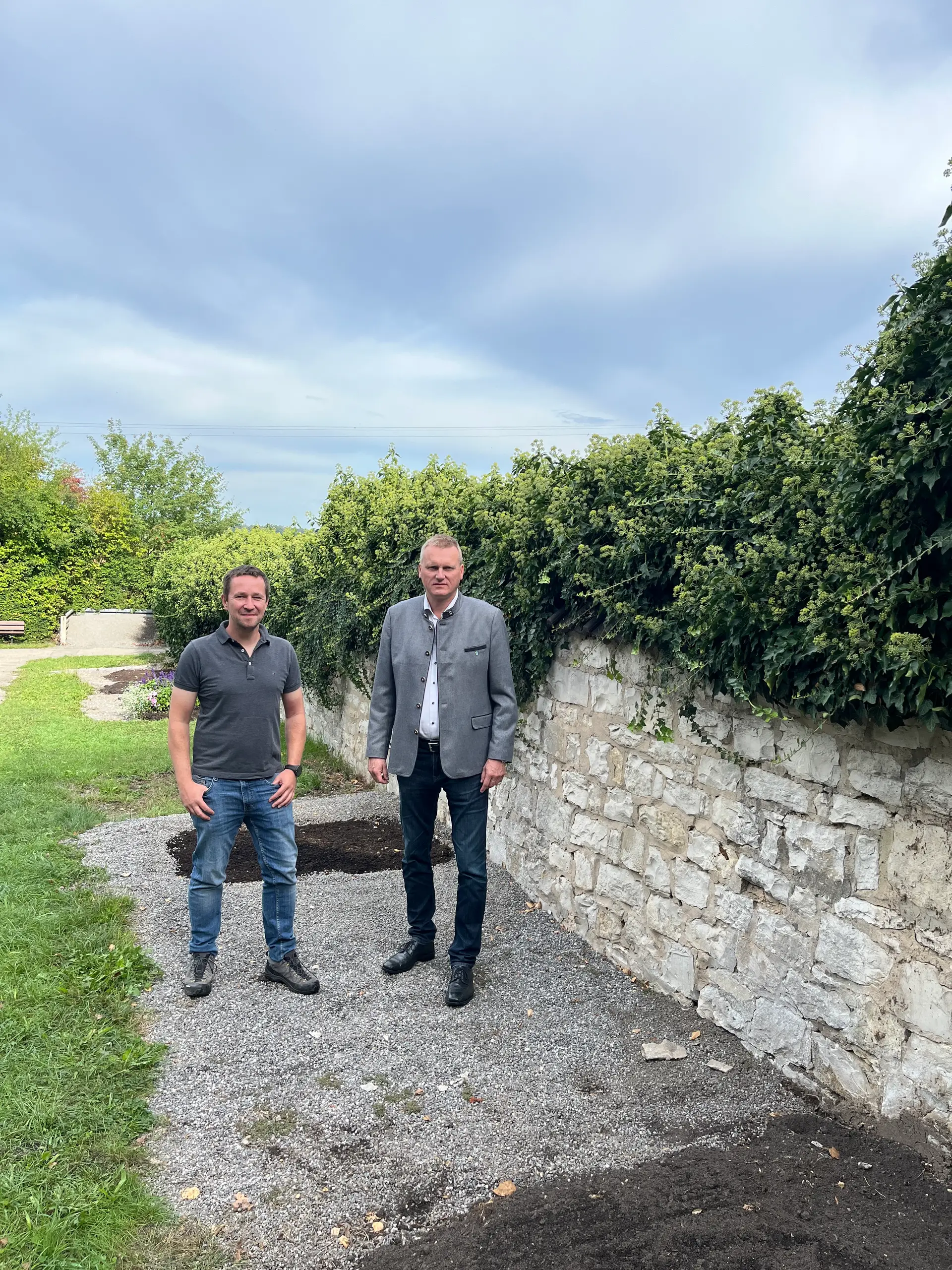 Vor Ort auf dem Friedhof Pirkensee: Erster Bürgermeister Rudolf Seidl (rechts) und Stadtbaumeister Ronny Harz besichtigen die sanierungsbedürftige Natursteinmauer zwischen dem alten und dem neuen Friedhofsteil.