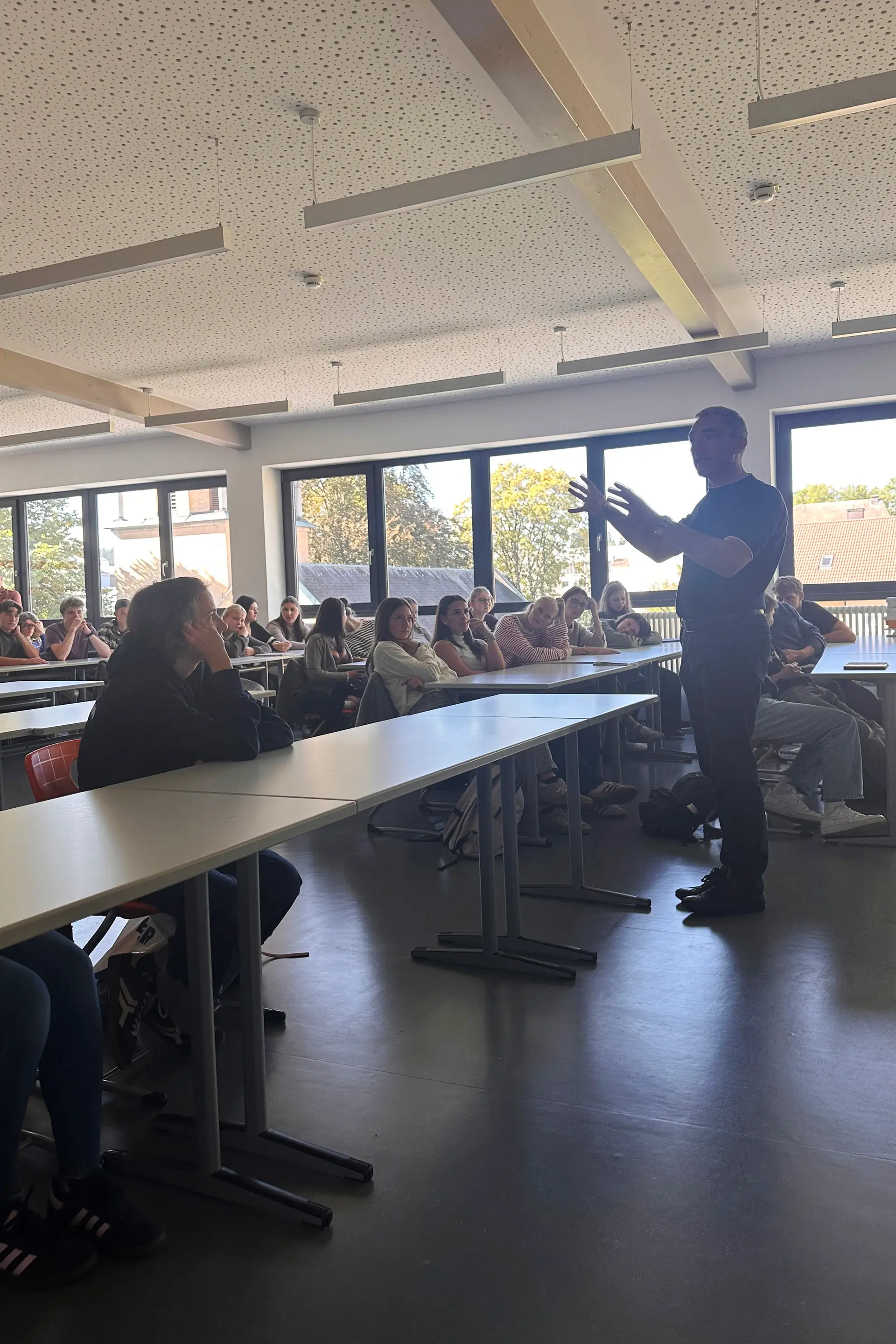 Landrat Dr. Ronny Raith steht vor Schülerinnen und Schülern und beantwortet deren Fragen.