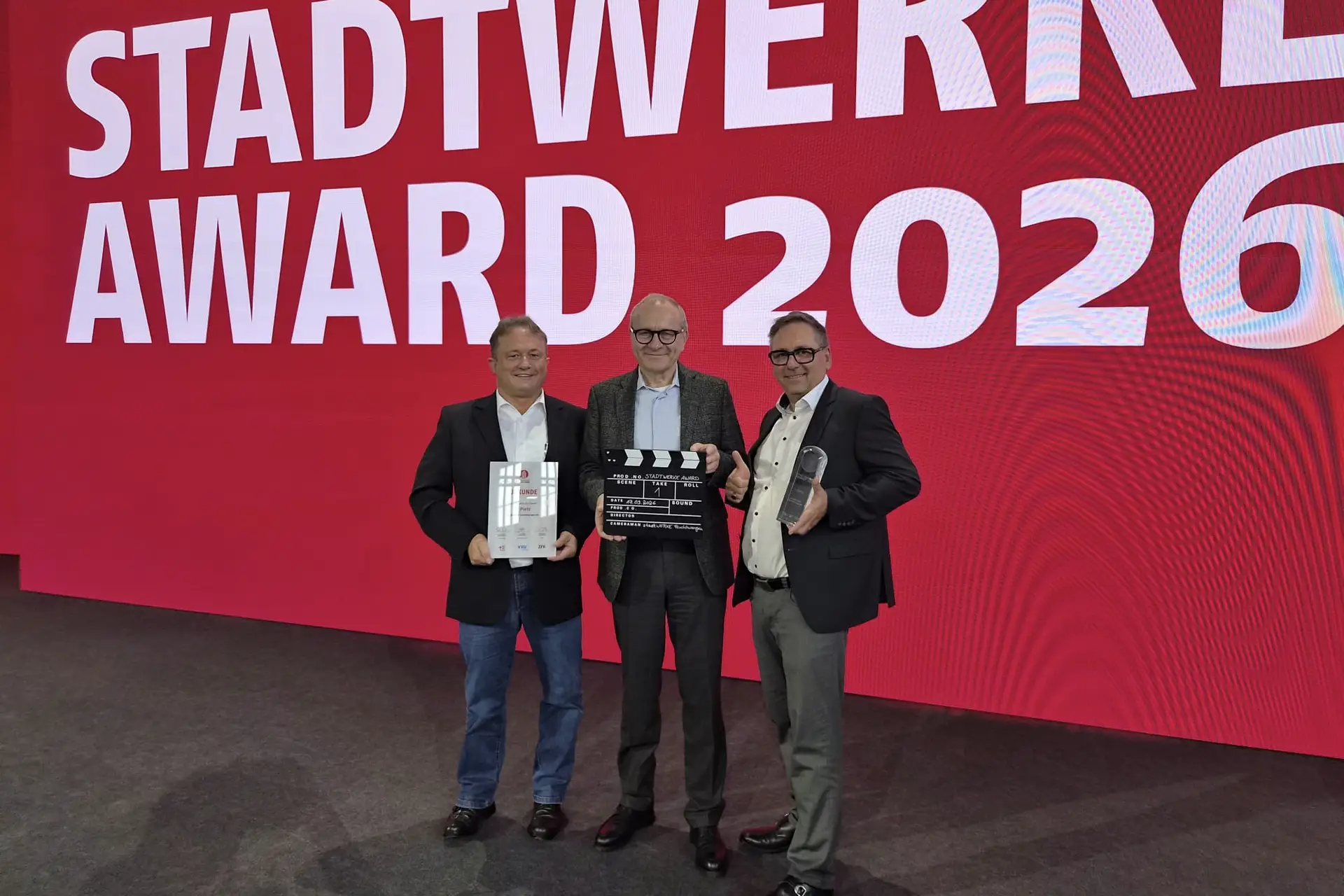 Gruppe von drei Personen in Berlin vor einem Preis-/Award-Kontext, darunter Bürgermeister Dr. Ulrich Grünwald sowie Vorstände der Stadtwerke Feuchtwangen.